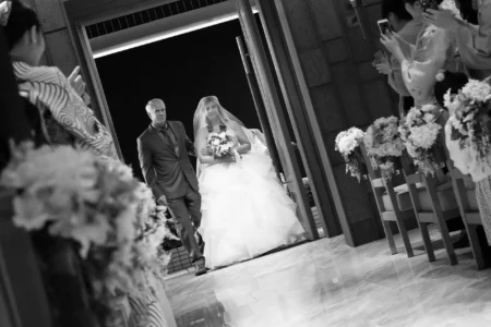 The bride enters the church aisle with her father. Bride entering the church aisle with her father during her wedding ceremony in Osaka, Japan.