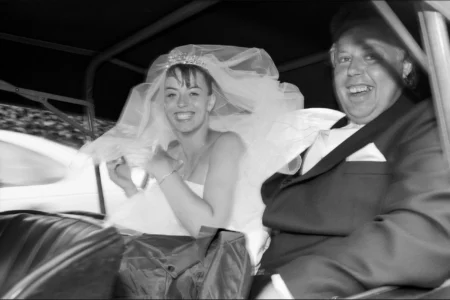 The bride arrives at the church with her father in a classic car. Bride arriving at the church with her father in a classic wedding car.