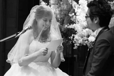 The bride reads her personal vows to the groom during their church ceremony. Bride reading personal vows to the groom during their wedding ceremony in Osaka, Kansai, Japan.