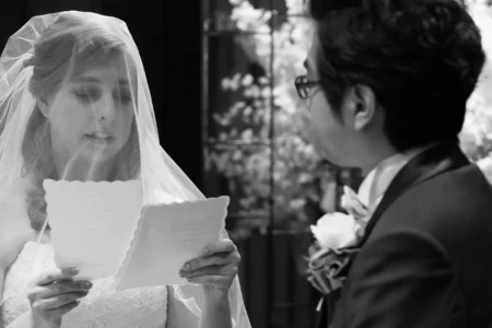 The bride reads from her notes as she speaks directly to the groom. Bride reading from notes during her personal vows at her wedding in Osaka, Japan.