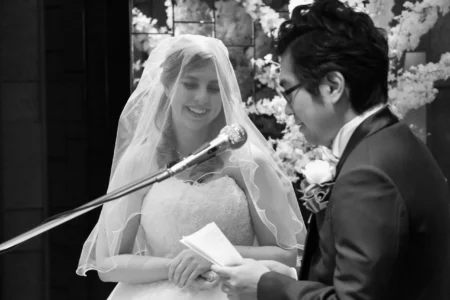 The groom reads his personal vows to the bride during their church ceremony. Groom reading personal vows to the bride during their wedding ceremony in Osaka, Kansai, Japan.