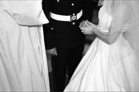 After exchanging vows, the bride and groom hold hands. Bride and groom holding hands after exchanging vows during their wedding ceremony.