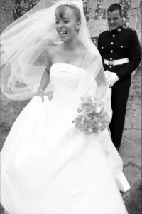 The wind catches the bride’s veil as the couple leave the church together. Bride and groom leaving the church as the wind catches the bride’s veil.