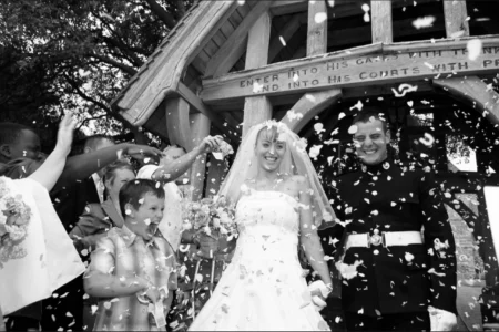 Guests shower the couple with confetti as they leave the church. Wedding guests throwing confetti over the bride and groom as they leave the church.