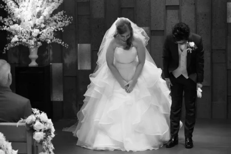 The bride and groom bow to their guests during the church ceremony. Bride and groom bowing to their guests during their church wedding in Osaka, Japan.