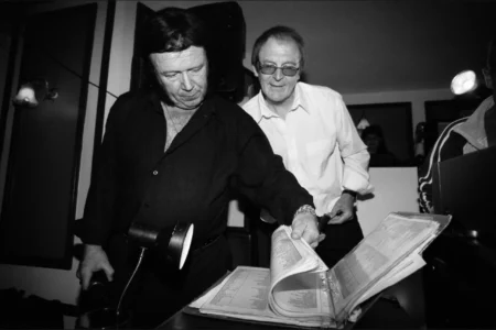 The DJ and Elvis impersonator look through the karaoke song list. DJ and Elvis impersonator looking through karaoke song lists at the wedding reception.