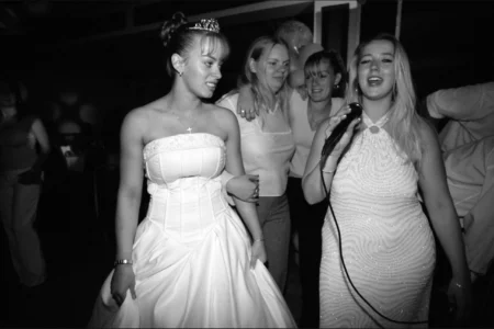 Family and friends enjoy karaoke, filling the room with smiles, laughter and the occasional off-key note. Family and friends singing karaoke and smiling during the wedding reception.