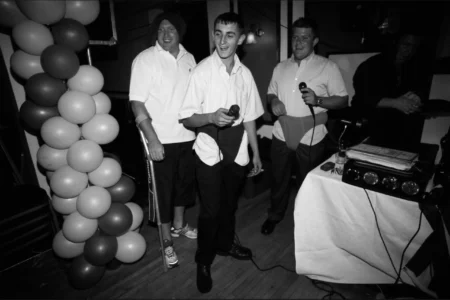 Friends of the groom laugh and sing together during the reception. Friends of the groom laughing and singing together at the wedding reception.