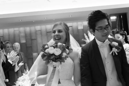 Guests throw confetti as the bride and groom walk together after the ceremony. Wedding guests throwing confetti over the bride and groom after their ceremony in Osaka, Japan.