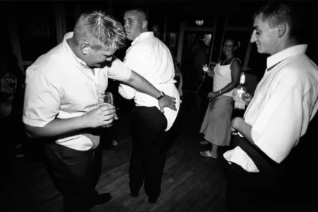 The groomsmen celebrate in Y-fronts worn over their trousers, bringing the reception firmly into party mode. Groomsmen wearing Y-fronts over their trousers while celebrating with drinks at the wedding reception.