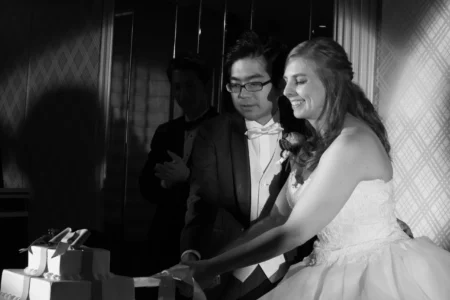 The bride and groom cut their wedding cake together during the reception. Bride and groom cutting their wedding cake during their reception in Osaka, Japan.