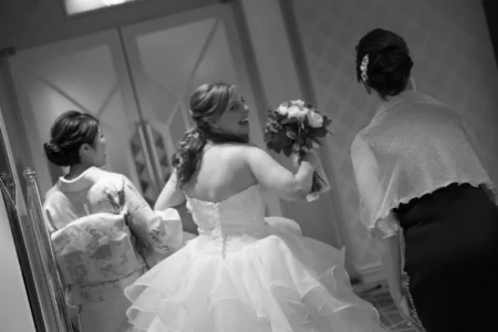 The bride is photographed with her mother and best friend during the reception. Bride with her mother and best friend during her wedding reception in Osaka, Japan.