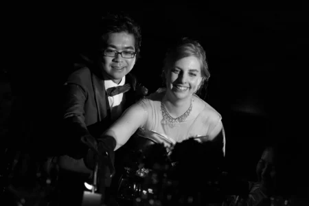 The couple visit each guest table for a candle-lighting moment. Bride and groom lighting candles during their wedding reception in Osaka, Kansai, Japan.