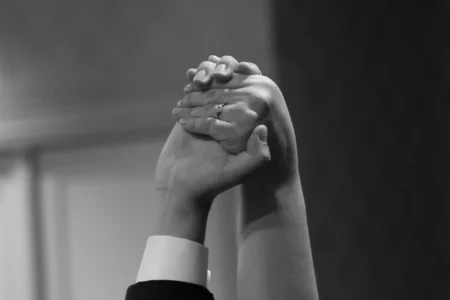 The bride and groom raise their hands in celebration at the end of the reception. Bride and groom raising their hands in celebration during their wedding reception in Osaka, Kansai, Japan.