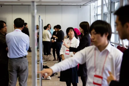 Conference delegates present and discuss research during a poster presentation session at The Asian Conference on Psychology & the Behavioural Sciences (ACP) in Osaka, Japan. ACP Poster Presentation Session in Osaka