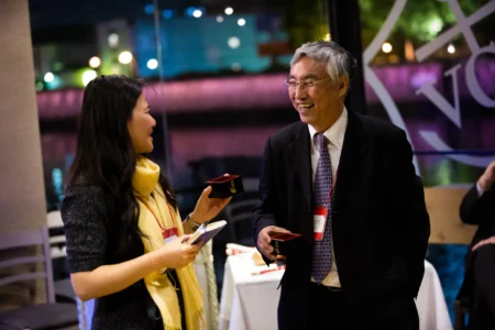 Delegates enjoy sake served in traditional masu boxes during The Asian Conference on Education (ACE) welcome reception in Osaka, Japan. Sake Served in Masu Boxes at ACE Osaka